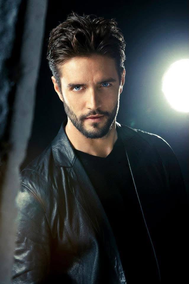 Ritratto maschile in giacca di pelle con barba curata e luce di taglio