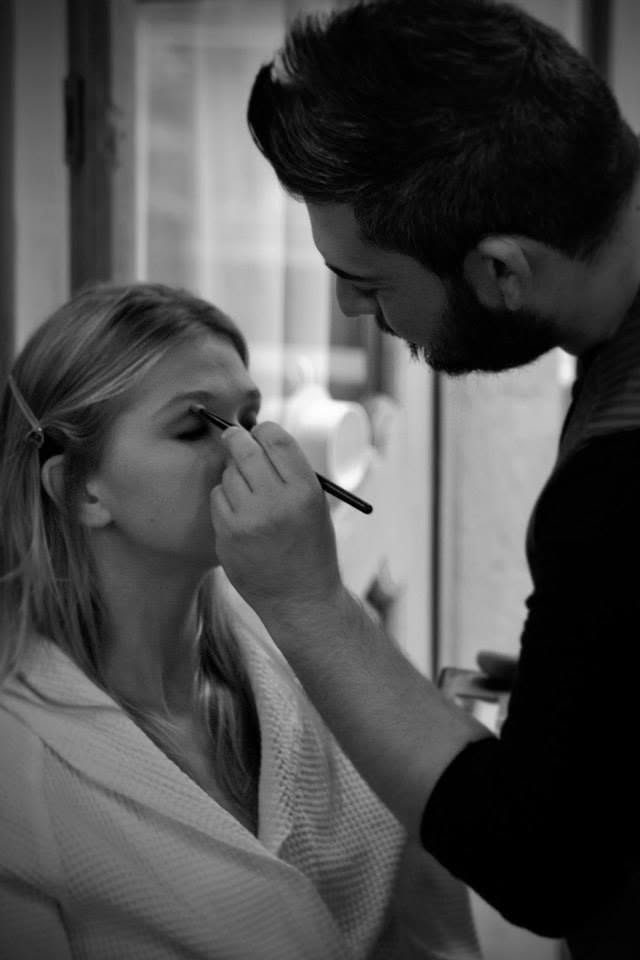 Preparazione del trucco: Antonio Lagani disegna l'eyeliner a una ragazza in accappatoio